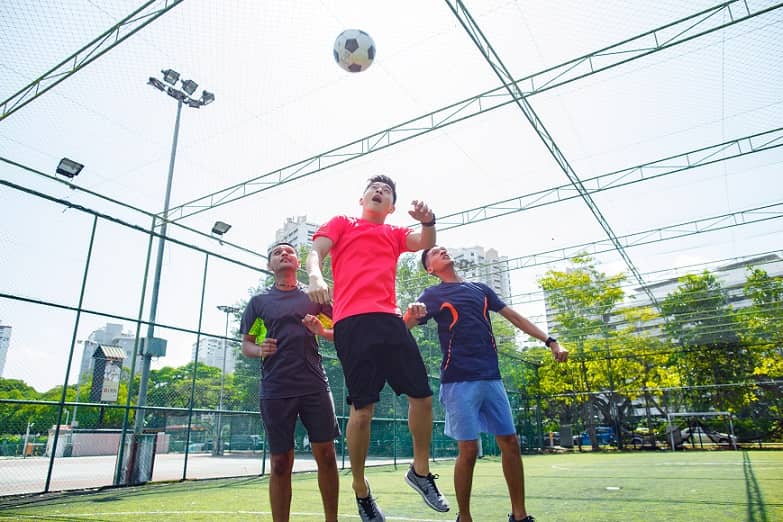 boy playing football with friends