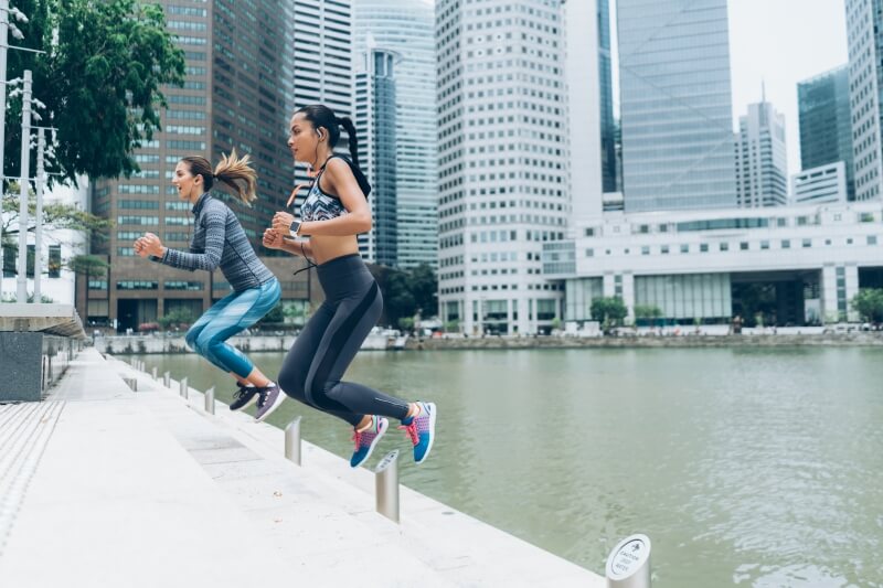 What is an active lifestyle – two women jumping and exercising in the city